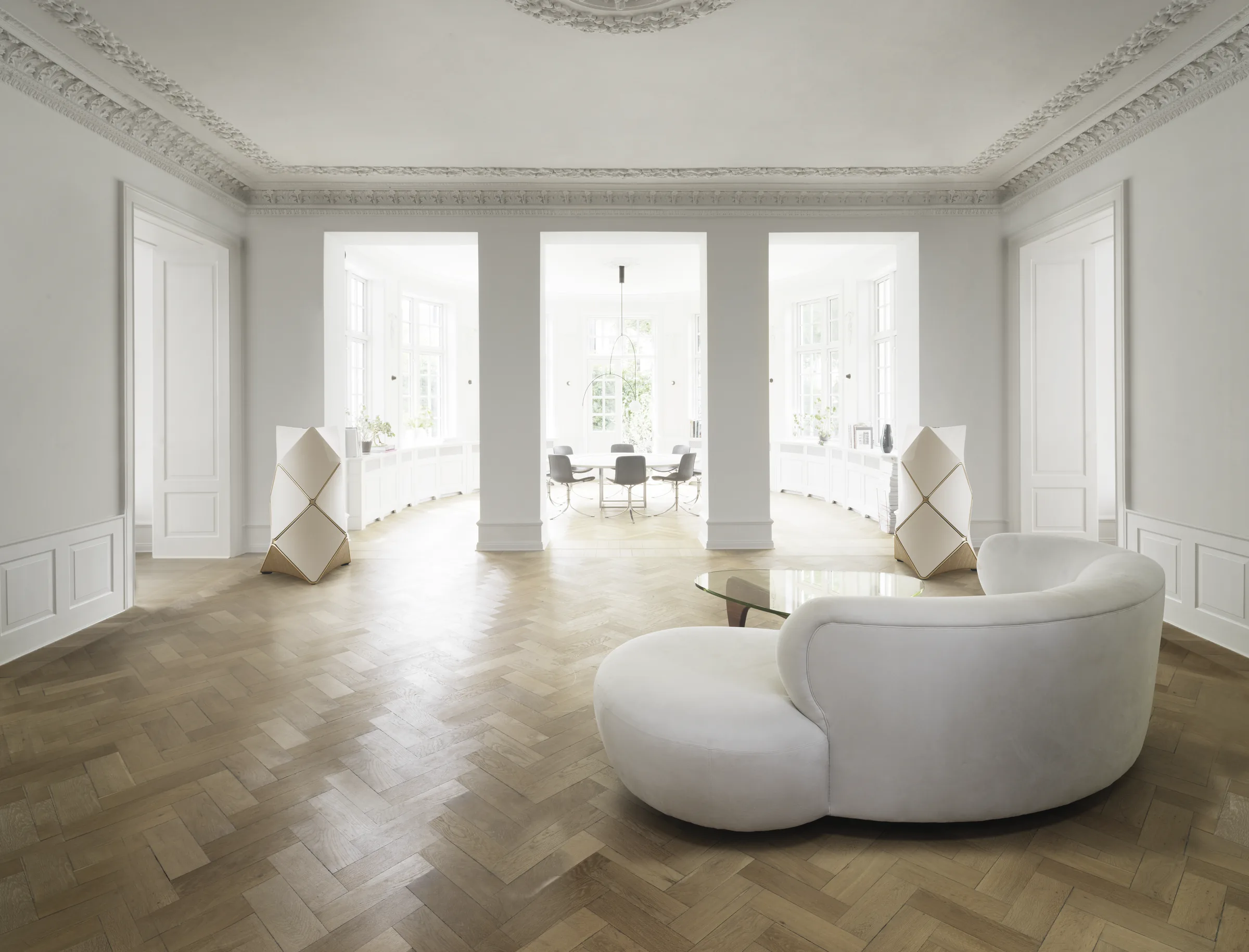 Pair of Bang & Olufsen Beolab 90 loudspeakers in white and gold-tone oak flanking a bright living room listening space