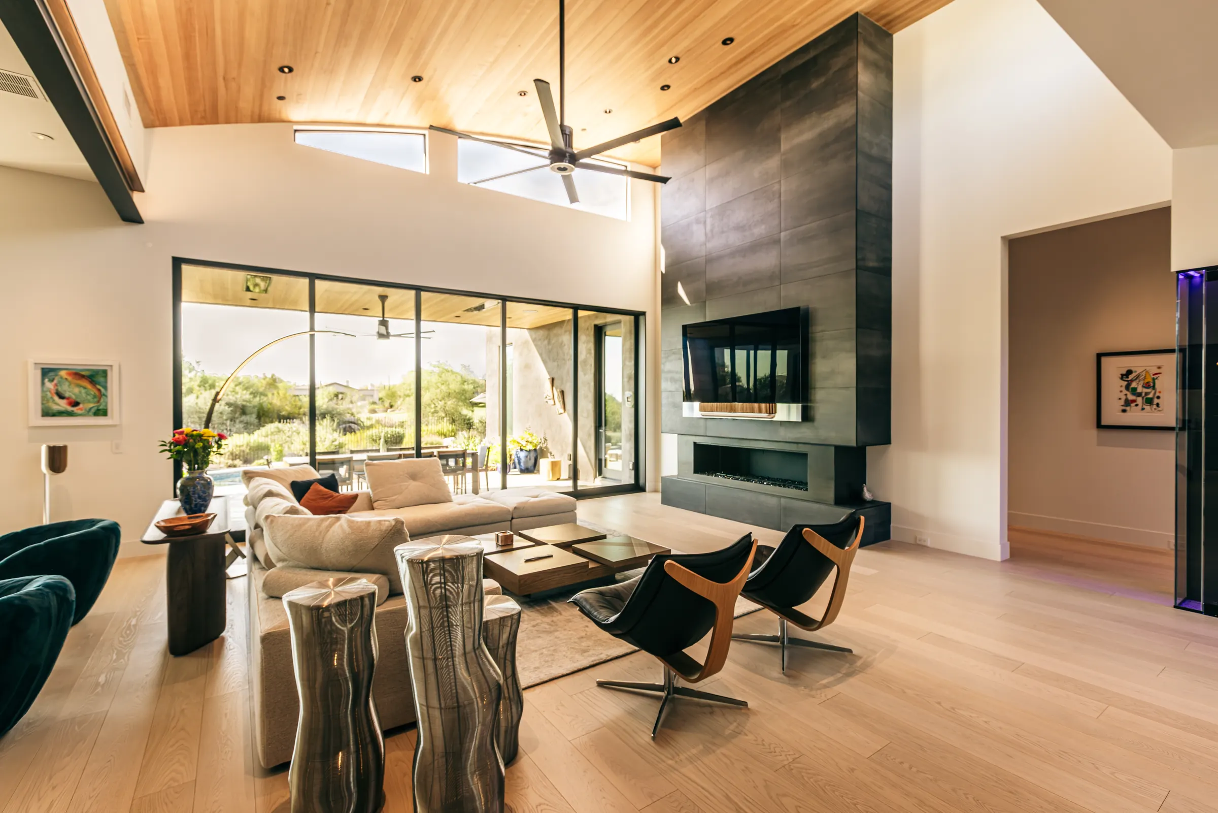 Living room with a wall-mounted TV and Bang & Olufsen Beosound Theatre soundbar integrated into a dark feature wall over a linear fireplace — Watt Integration project home
