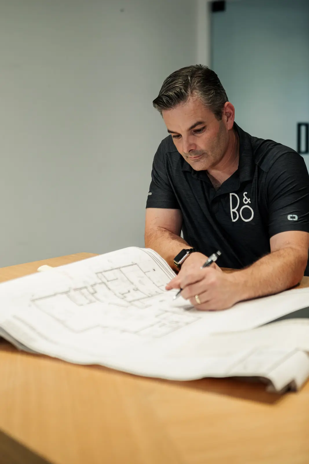 Bryan Watt marking up a set of architectural drawings on a table