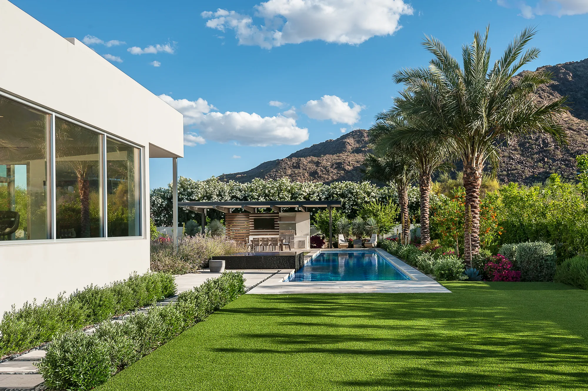 Pool, lawn and shaded outdoor entertainment ramada in daylight